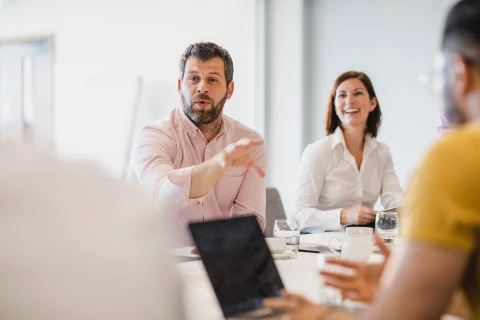 A man and a woman smiling & discussing a meeting