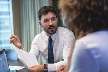 A man in a business suit engages in conversation about legal strategies