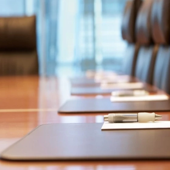 A conference table with pens and books placed on a table