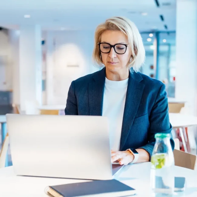 A woman Attorney reading about cases on a laptop in an office