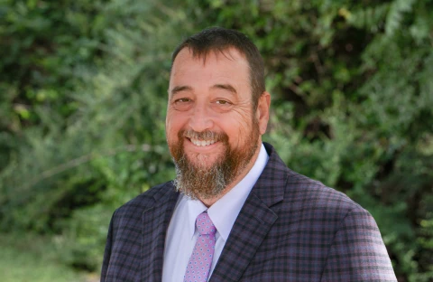 Jody Braxton, in a suit with a beard, serves as a Solution Advisor at IMS Legal Strategies