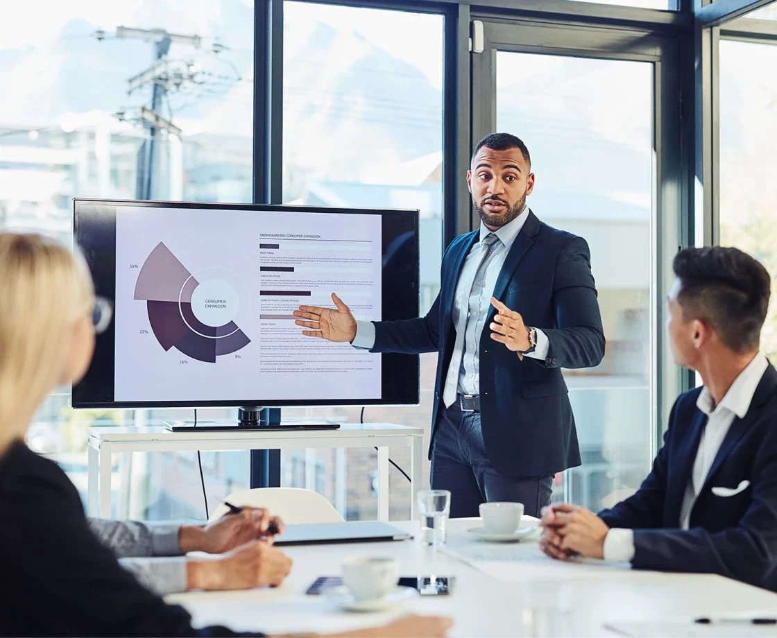 A man in a suit presents Litigation Analytics insights to colleagues at IMS Legal Strategies