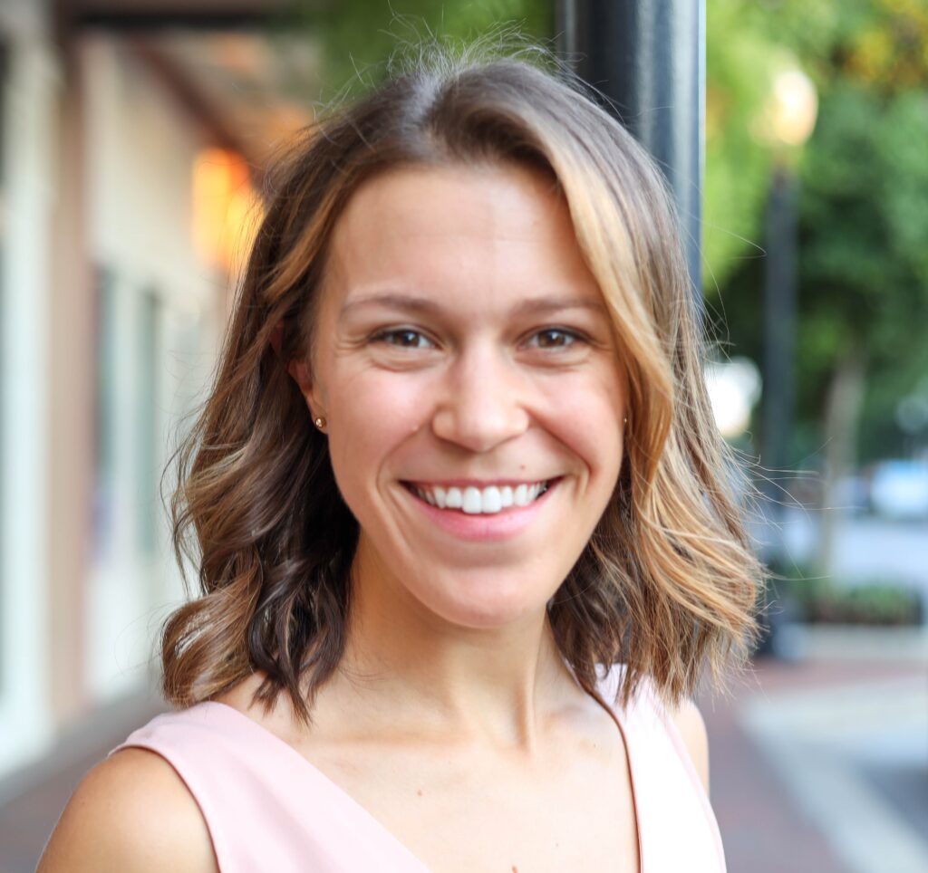 Sarah Lee, Revenue Operations Manager, smiles in front of a building for IMS Legal Strategies